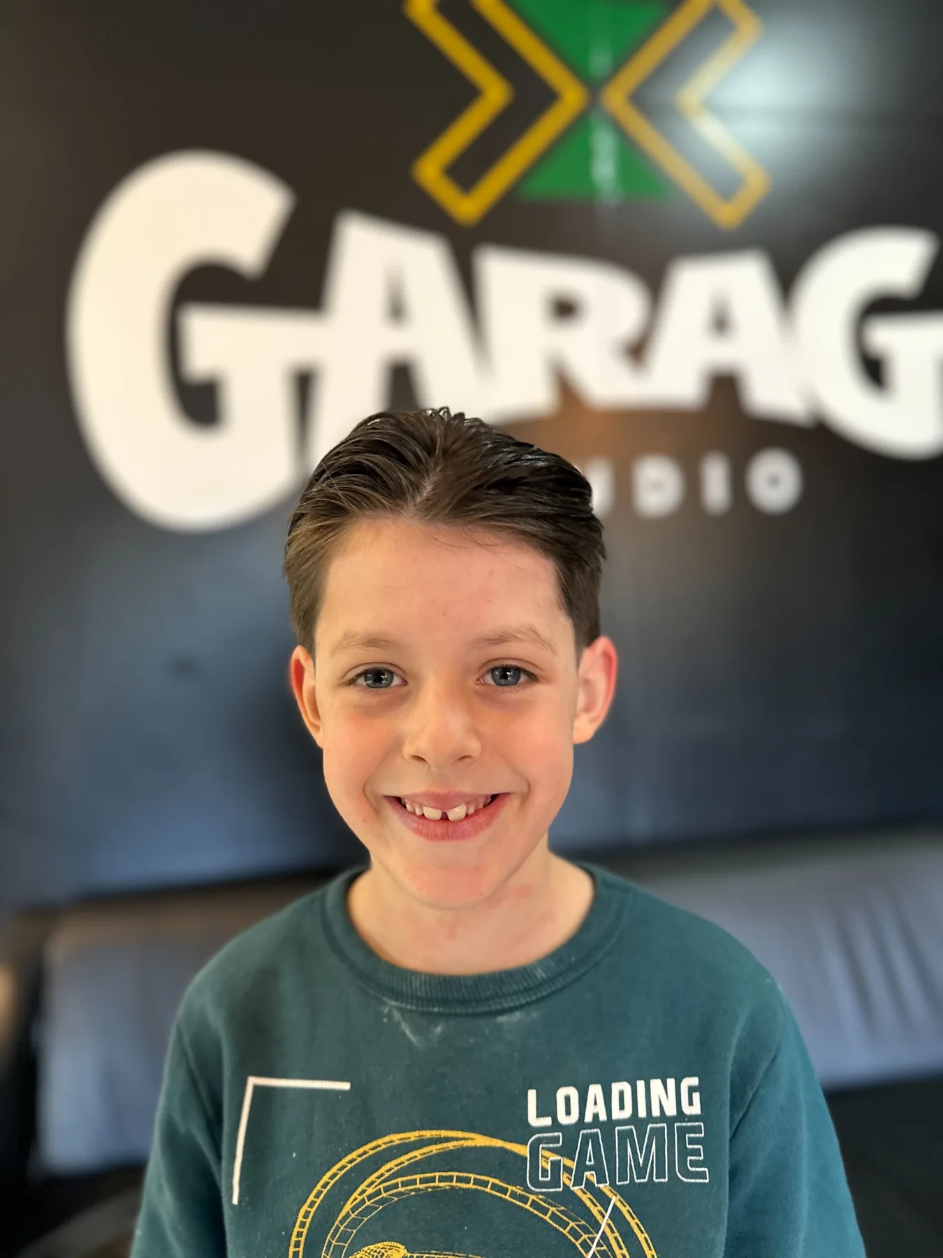 Corte infantil com a identidade da Garage Studio ao fundo